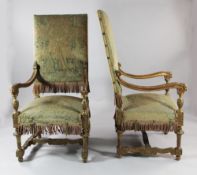 A pair of Louis XIV style carved giltwood open armchairs, with high backs and scrolling arms