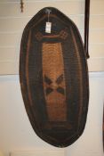 A Central African woven wicker shield, with geometric motifs and tapering ends, 43in.