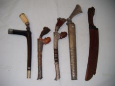 A Malaysian hardwood and white metal mounted bade bade, together with three other bade bade`s and an