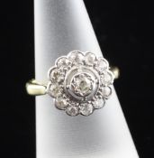 An 18ct gold diamond cluster ring, of flower head design, set with thirteen old cut diamonds, size