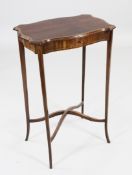 An Edwardian mahogany and satinwood banded work table, with serpentine shaped top, on tapering