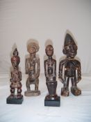 A West African Yoruba carved figure of a standing female, together with three other carved African