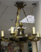 A French Empire style chandelier, with ormolu mounts and circular body issuing six masked sconces