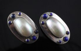 A stylish pair of sterling silver, mother of pearl and lapis lazuli earrings, of oval form, each set
