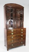 A George III mahogany secretaire bookcase, the arched top with fan inlay over two glazed doors, a