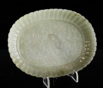 An Indian celadon jade oval dish, 19th century Mughal style, the centre carved with flowers and