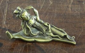A small Chinese bronze figure of He Xiangu, reclining on a leaf, 19th century, 9cm.