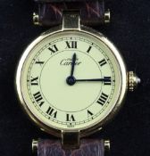 A lady`s silver gilt Cartier quartz wrist watch, with Roman dial, on Cartier leather strap.