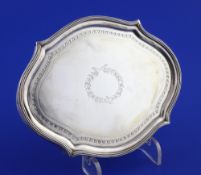 A George III silver mounted wooden teapot stand, of shaped oval form, with engraved decoration and