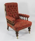 A Victorian walnut upholstered armchair, with red and gold floral patterned fabric, on turned