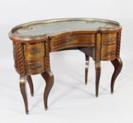 An early 20th century Continental mahogany kidney shaped desk, with pierced brass gallery top and