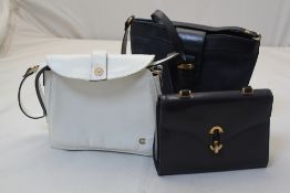 A Shura white leather handbag and two other blue leather handbags