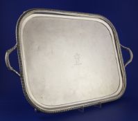 A George III silver two handled tea tray, of rounded rectangular form, with engraved armorial and