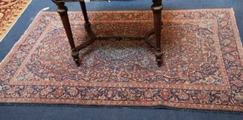 A pair of Kashan rugs, with geometric fields of scrolling foliage on a red and blue ground, with