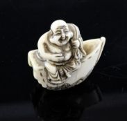 A Japanese ivory netsuke of Hotei, seated on a boat, 19th century, holding his sack of wind over his