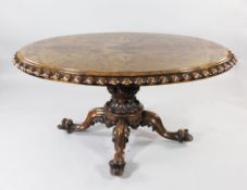 A Victorian oval walnut breakfast table, with gadrooned border and quarter veneered top, on a turned