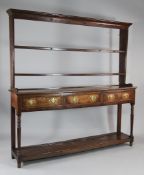 A George III oak dresser, with open plate rack above three frieze drawers and pot board below, on