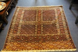 A Yomut Hatchli rug, with four panels of stylised foliate motifs, on a deep red ground, with