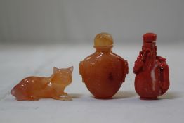 A Chinese coral snuff bottle, an agate snuff bottle and a recumbent cat, mid 20th century, the coral