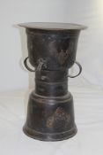 An Indonesian circular bronze rain drum, cast with figural motifs and four lug handles, 20in.