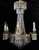 A 20th century brass and glass lustre drop chandelier, with six scrolling branches, each sconce with