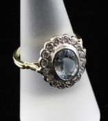 An 18ct gold, aquamarine and diamond cluster ring, of oval form, with diamond set border, size O.