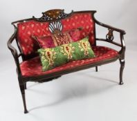 An Edwardian mahogany and marquetry inlaid settee, with red and gold pattern upholstery and