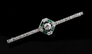 A 1930`s white gold, emerald and diamond set bar brooch, with central diamond shaped motif, 2.25in.