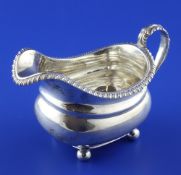A George IV silver cream jug, of rounded rectangular form, with gadrooned border, on ball feet,