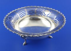 An Edwardian silver circular fruit bowl, the border with pierced wavy decoration, on tripod scroll