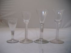 Four 18th century drinking glasses, the first with bell bowl above a double tape opaque stem, an