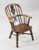 A 19th century yew wood child`s Windsor chair, with elm seat and crinoline stretcher