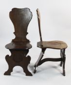 A pair of George II mahogany hall chairs, with shaped curved backs and dished seats, on shaped
