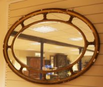 A 19th century oval gilt neo-classical style wall mirror, the central bevelled glass plate