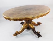 A Victorian oval burr walnut loo table, with wavy frieze, on octagonal vase shaped column and scroll