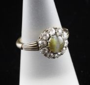 An Edwardian gold, tiger`s eye cabochon chrysoberyl? and diamond cluster ring, with fluted