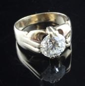 A gentleman`s gold and solitaire diamond ring, the claw set round brilliant cut stone weighing