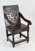 A 17th / 18th century oak armchair, with geometric moulded panelled back and downswept arms