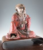 A large Japanese lacquered wood figure of a rakan, early 20th century, seated wearing red robes