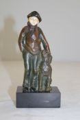 A patinated bronze and ivory figure of a boy and dog, on a square black marble base, signed A.