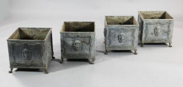 A set of four square lead garden planters, with lion masks and strap work borders, W.1ft 1in.