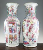 A pair of large Canton decorated famille rose vases, each painted with soldiers in a courtyard