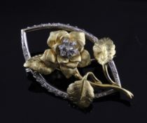 An 18ct two colour gold and diamond set brooch, modelled as a rose within a navette shaped border,