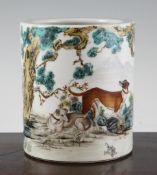A Chinese famille rose cylindrical brush pot, painted with dogs beneath a pine tree after
