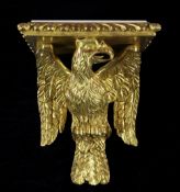 A carved giltwood wall bracket, modelled as an eagle below an rectangular white marble top, with