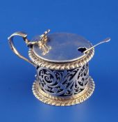 An Edwardian pierced silver drum mustard, with gadrooned borders, blue glass liner and pierced
