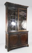 A George III style mahogany bookcase, fitted with a pair of astragal glazed doors over two