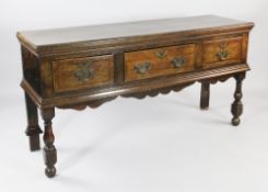 An 18th century oak dresser base, fitted three drawers with wavy apron, on vase turned supports, W.