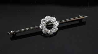 An 18ct gold bar brooch with eight old cut diamonds modelled as a flower head, 2in.