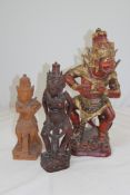 An Indonesian carved and painted figural kris stand, modelled as a red demon, together with two